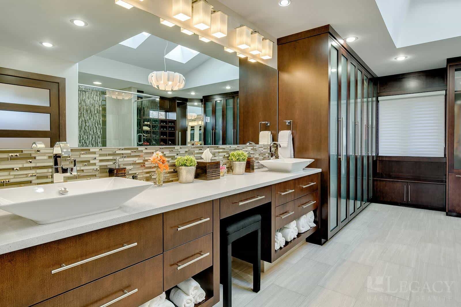 Expansive bathroom interior featuring granite sink surfaces and wooden storage cabinetry