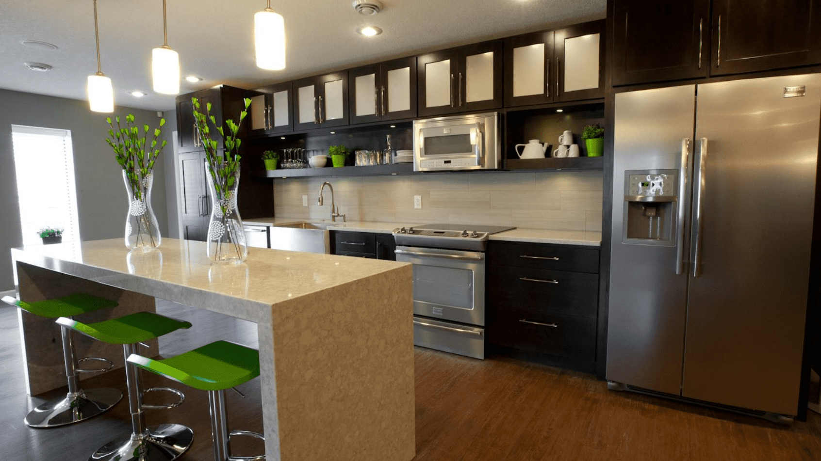 Modern kitchen with quartz countertop, stainless appliances, and brown cabinetry Lima